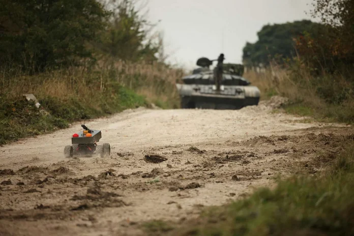 Безпілотний наземний транспортний засіб британської армії (UGV), оснащений вибуховими зарядами, дистанційно маневрує до основного бойового танка на полігоні Salisbury Plain Training Area. (Джерело фото: Британське оборонне відомство)